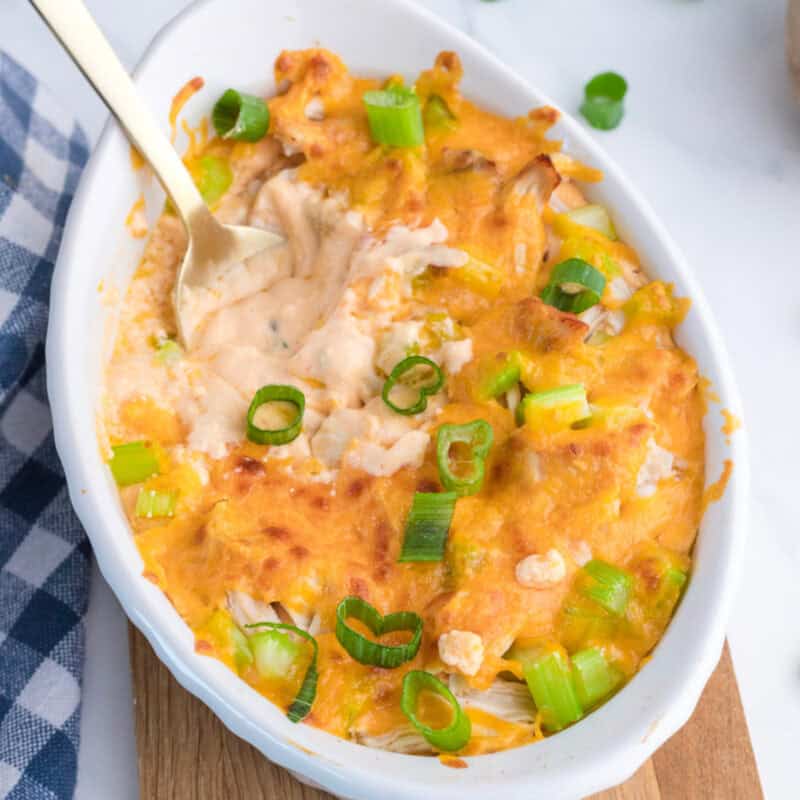 healthy cottage cheese buffalo chicken dip in a white dish with a spoon in it.