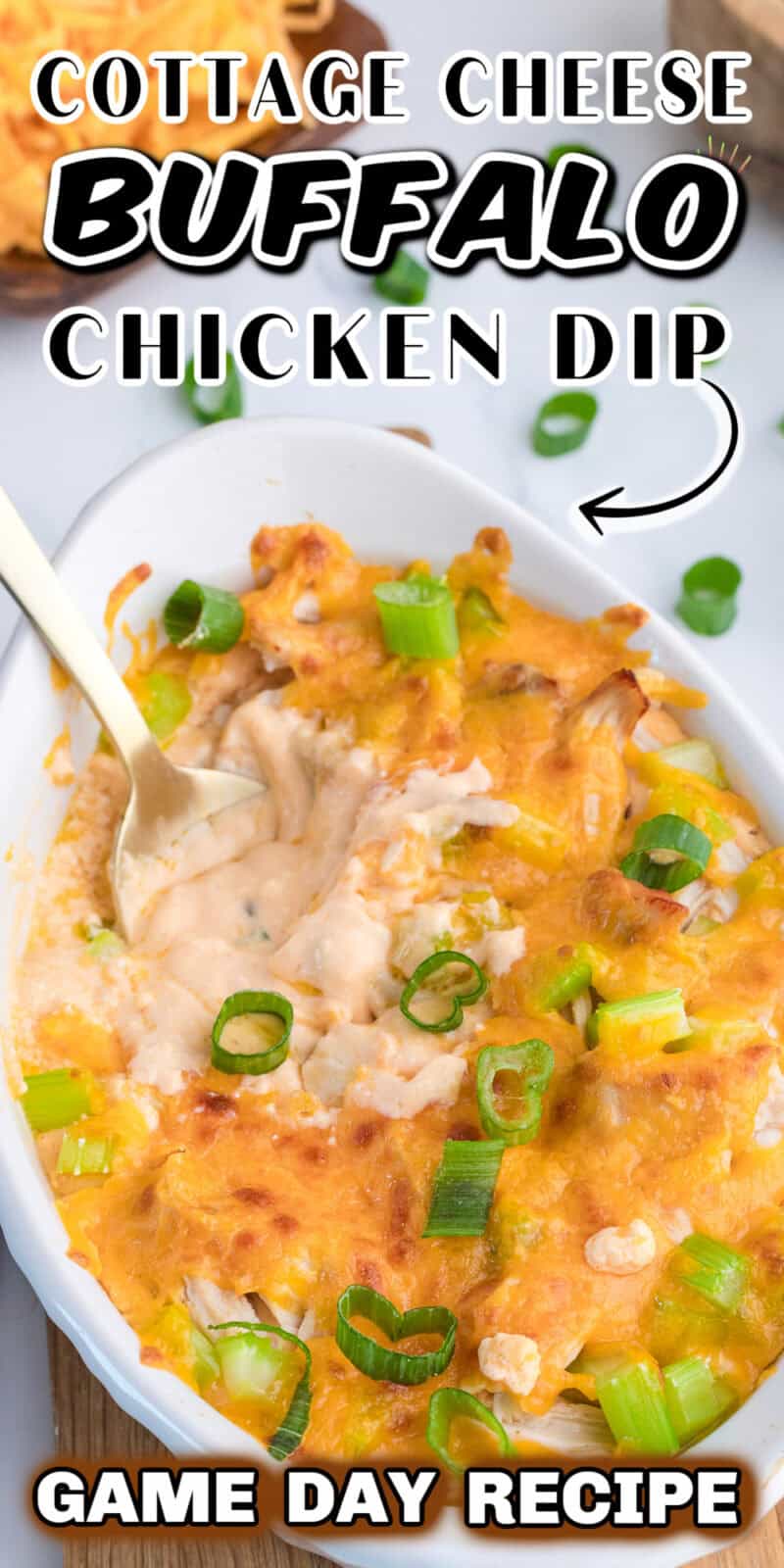Buffalo Chicken Dip made with cottage cheese in a white baking dish on a table with a spoon in it.