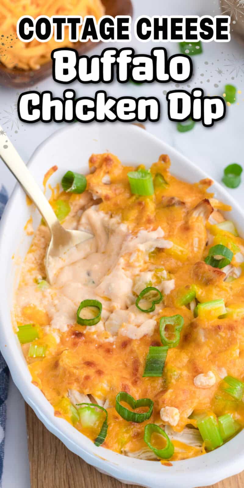 Buffalo Chicken Dip made with cottage cheese in a white baking dish on a table with a spoon in it.