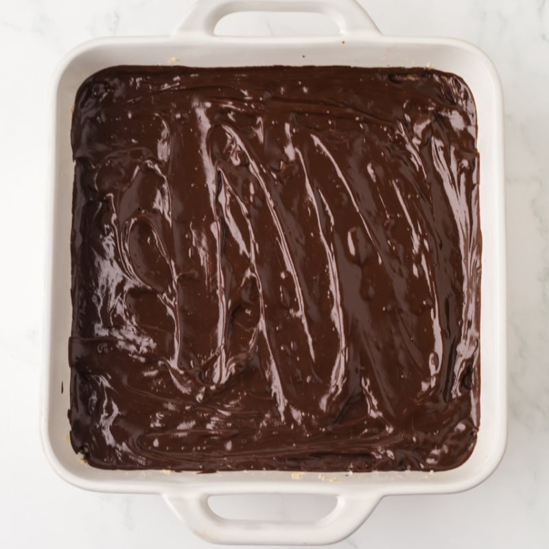 chocolate ganache in a baking dish to make chocolate shortbread bars.