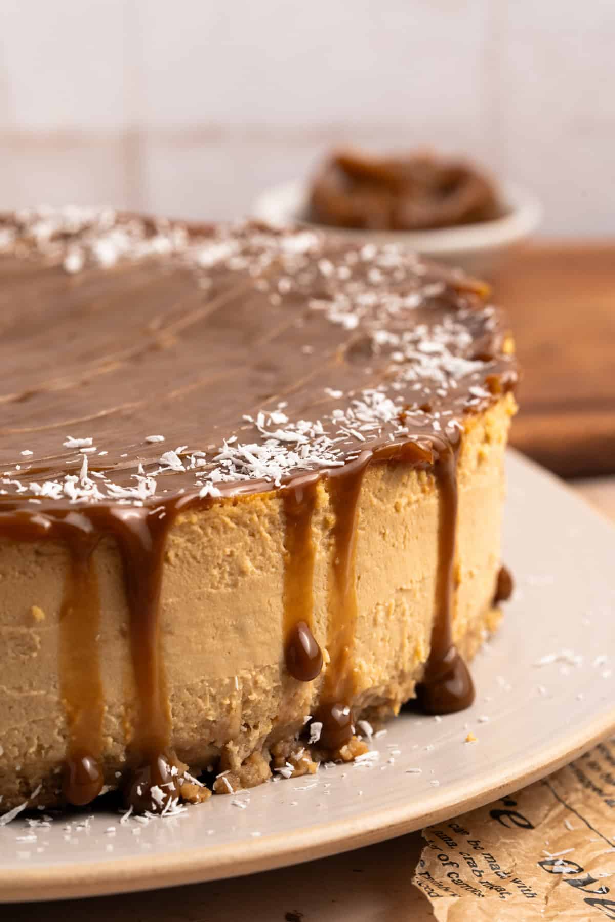 A whole Dulce de Leche Cheesecake with shredded coconut on top.