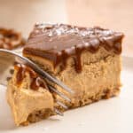 A fork taking a piece from a slice of Dulce de Leche Cheesecake.