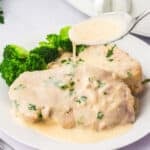 Sauce being poured onto Slow Cooker Creamy Ranch Pork Chops.