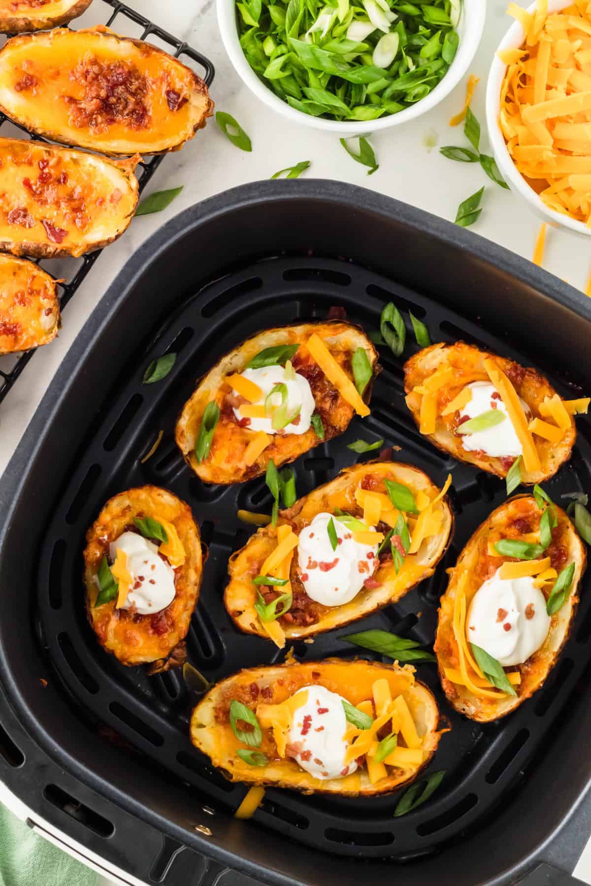 potato skins in an air fryer basket.
