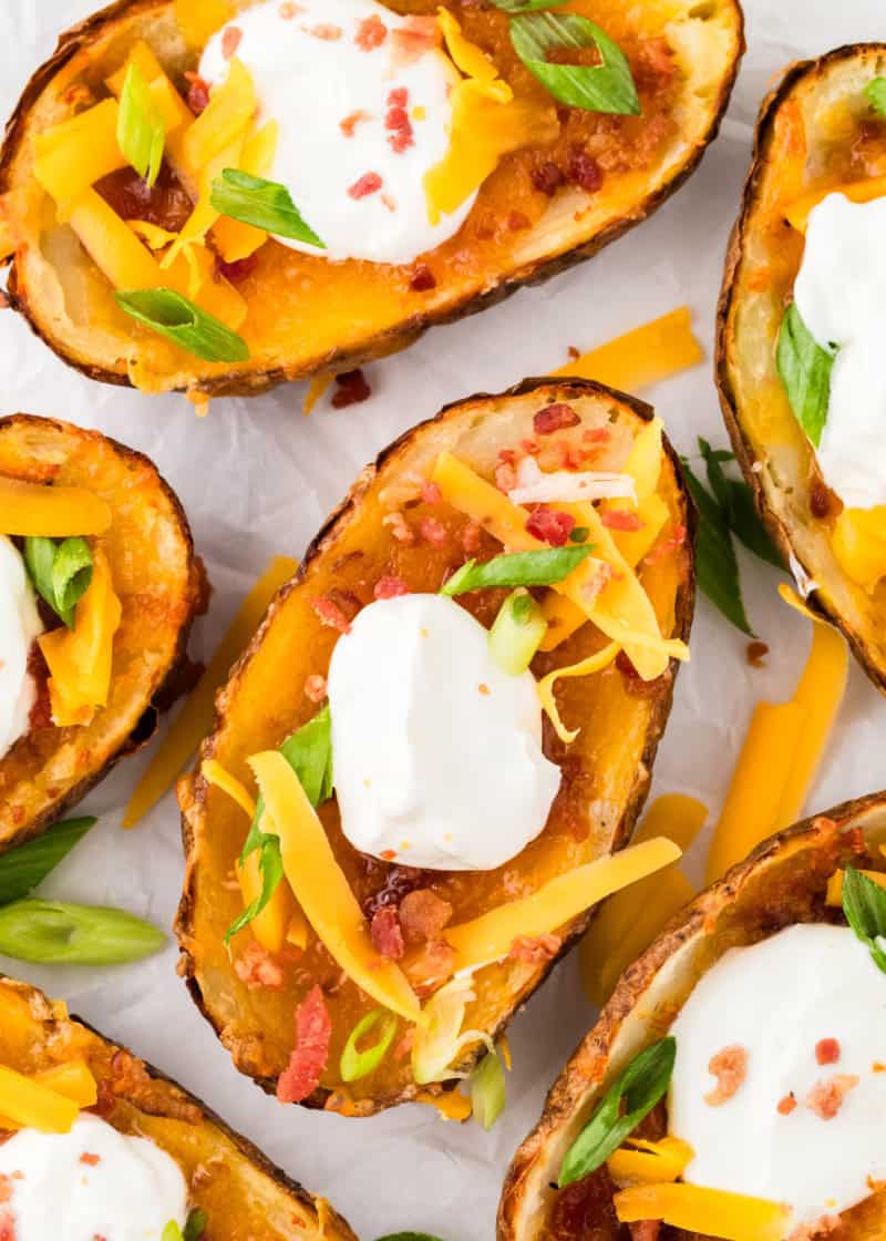 Air Fryer Potato Skins with green onions and sour cream on them.