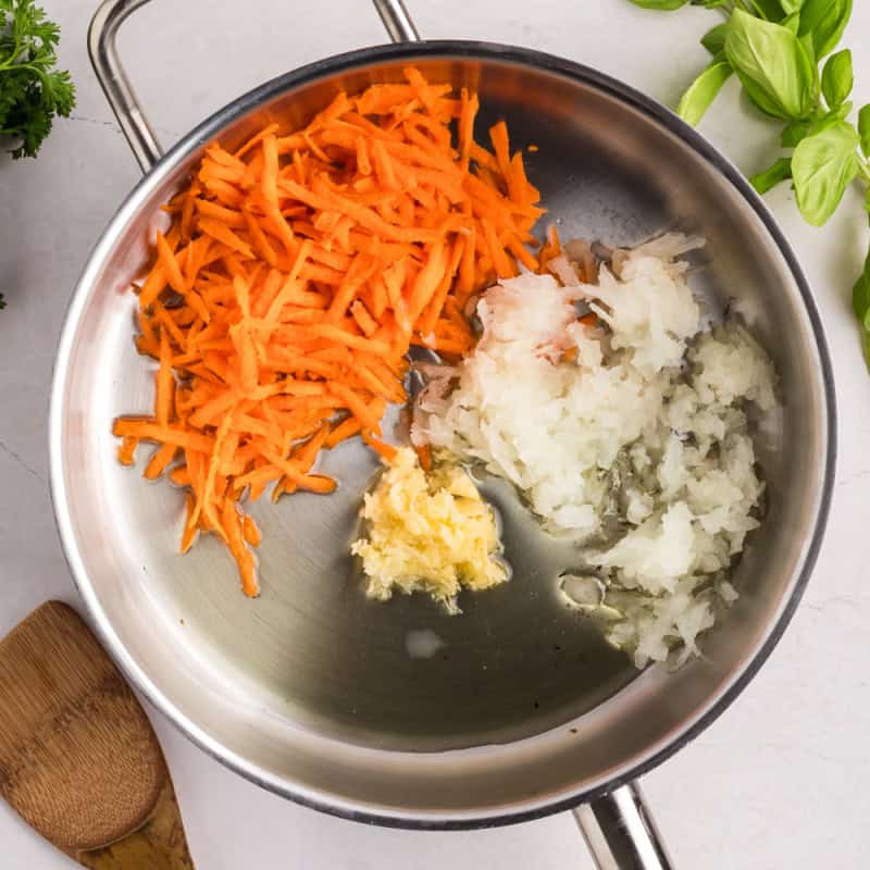 grated carrot, onion and garlic in a large cooking pot.