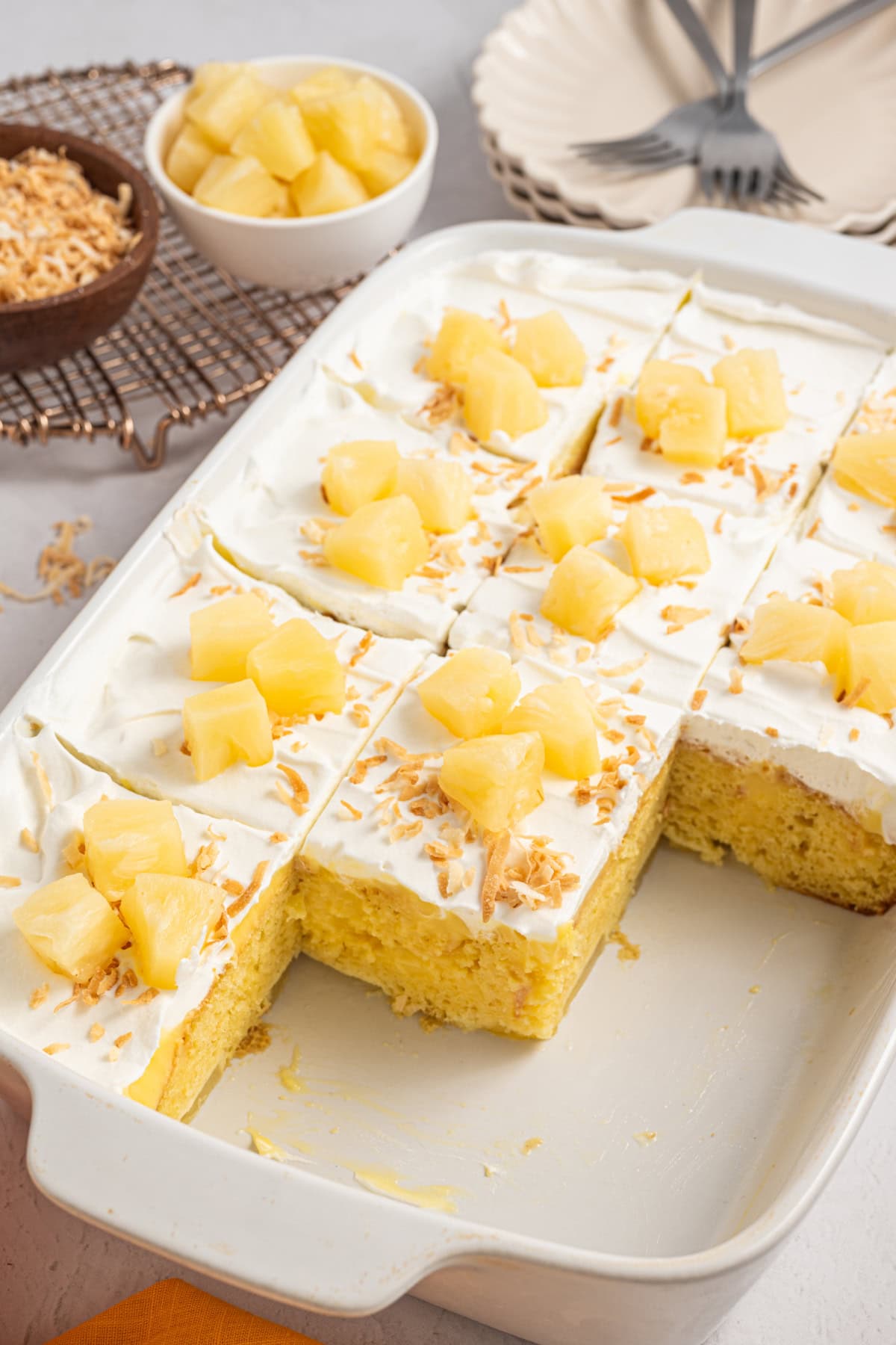 A Pineapple Poke Cake with some pieces already taken out.