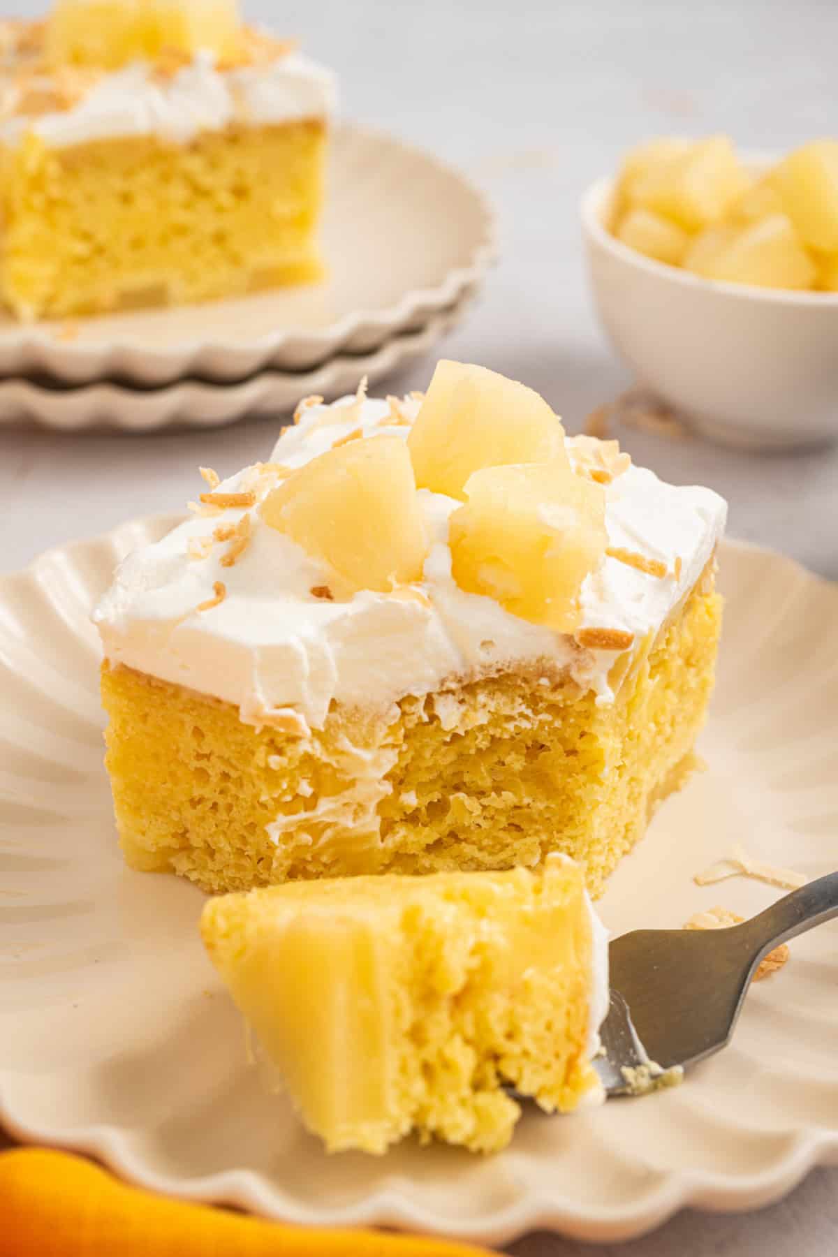 Pineapple Poke Cake on a plate with a fork.