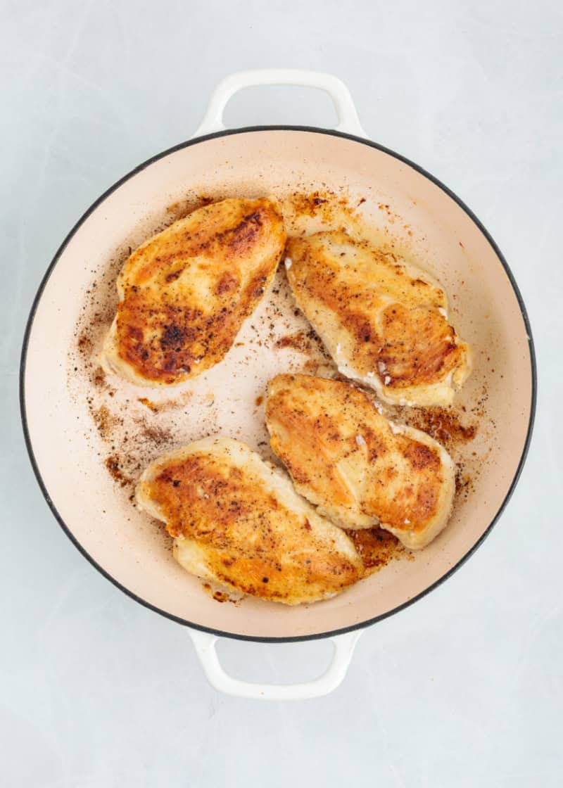chicken breasts browned in a pan.