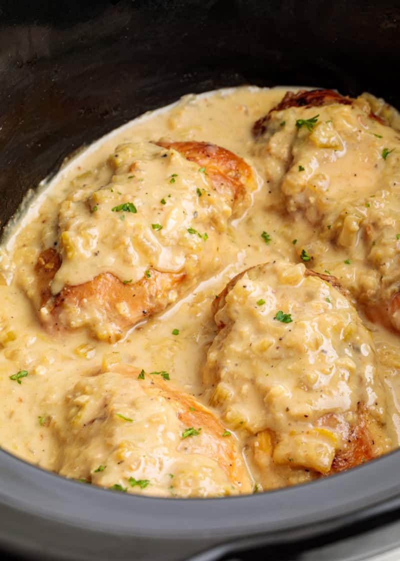 chicken breasts smothered in gravy and spices in a crockpot.