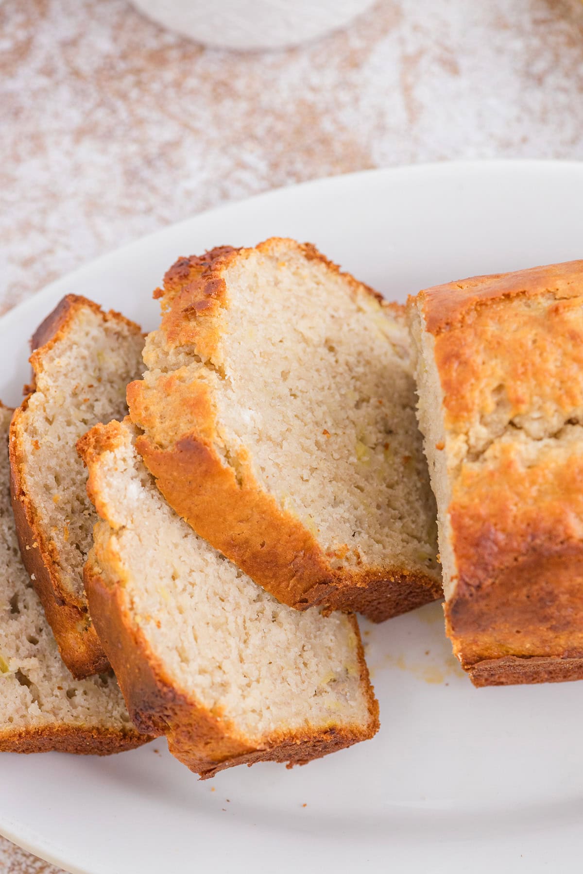 Sliced loaf of Bisquick Banana Bread on a white plate.