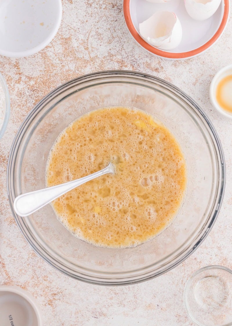 A mixture in a glass bowl to make banana bread.