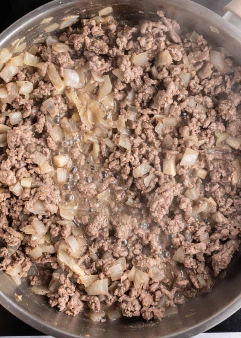 ground beef and onion cooking in a frying pan.