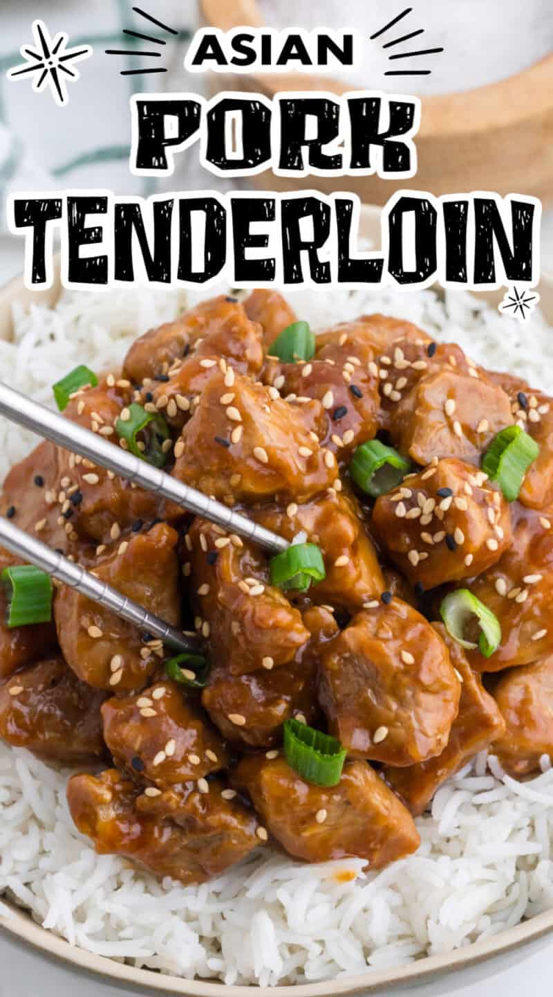 Asian Pork Tenderloin over rice in a bowl, with chopped green onion and sesame seeds on top.