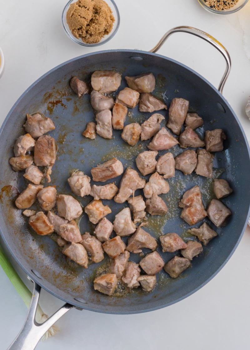 Cubed pork tenderloin cooking in a pan.