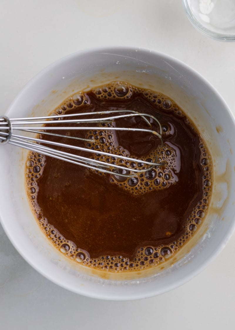 asian sauce being mixed in a bowl with a whisk.