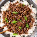 Korean ground beef in a bowl over rice and topped with green onions.