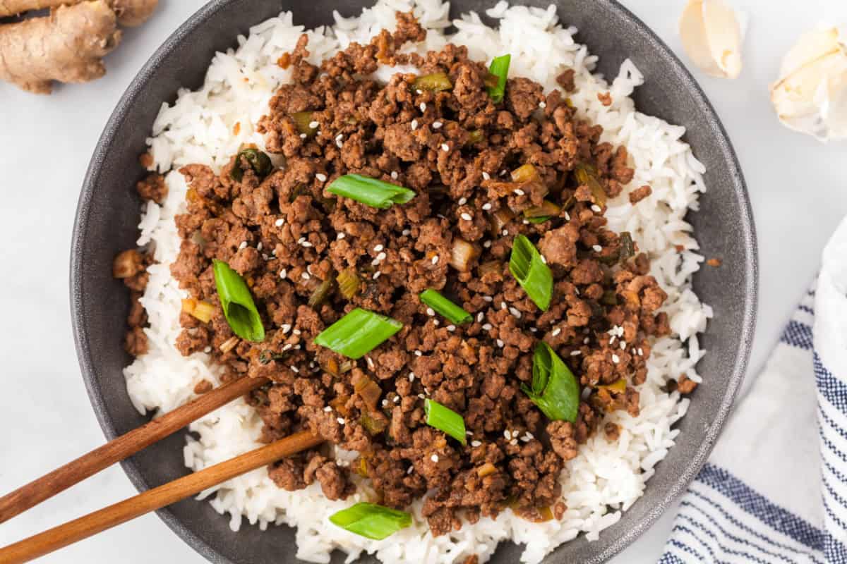 Korean ground beef in a bowl over rice and topped with green onions.