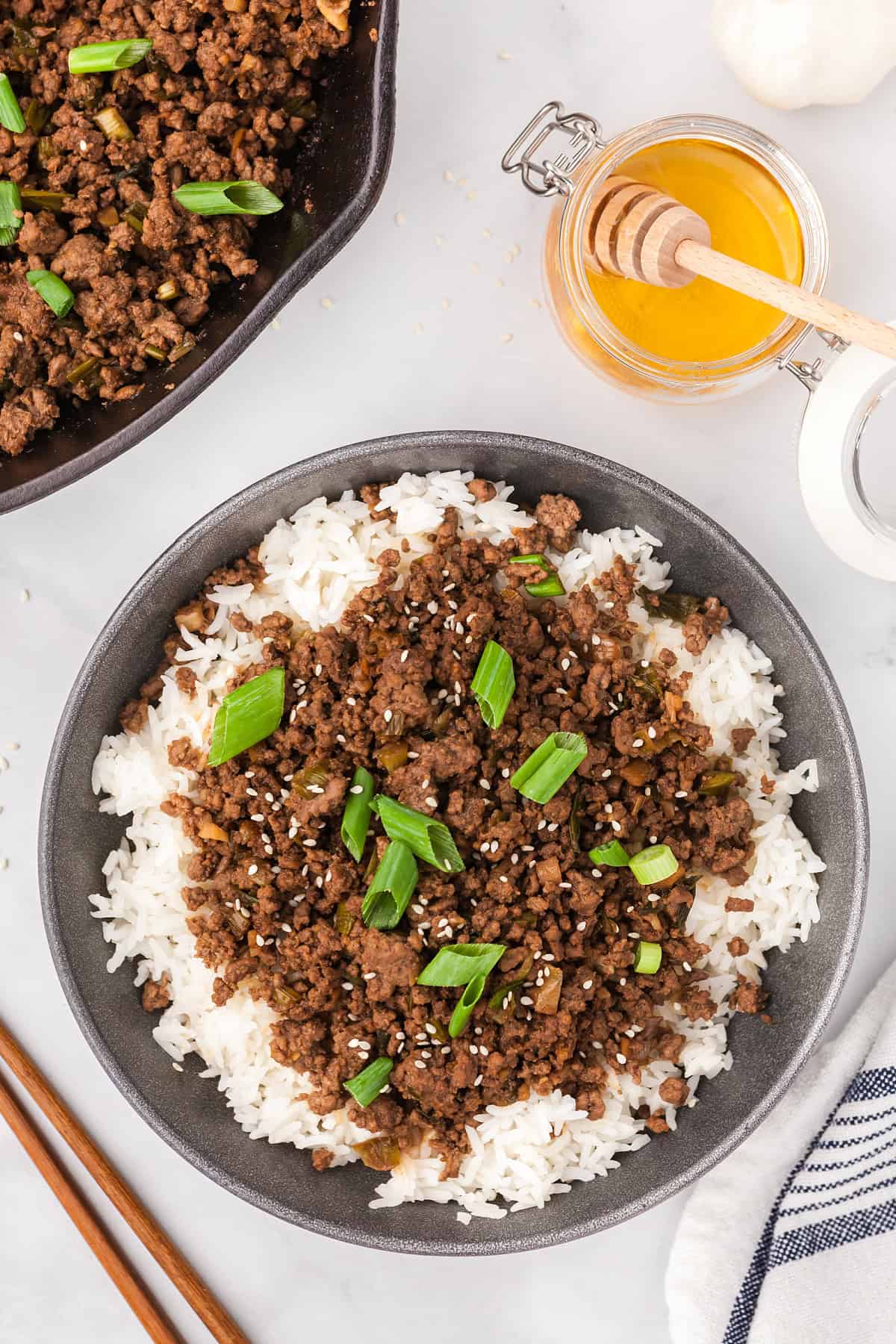 Korean ground beef in a bowl over rice and topped with green onions.
