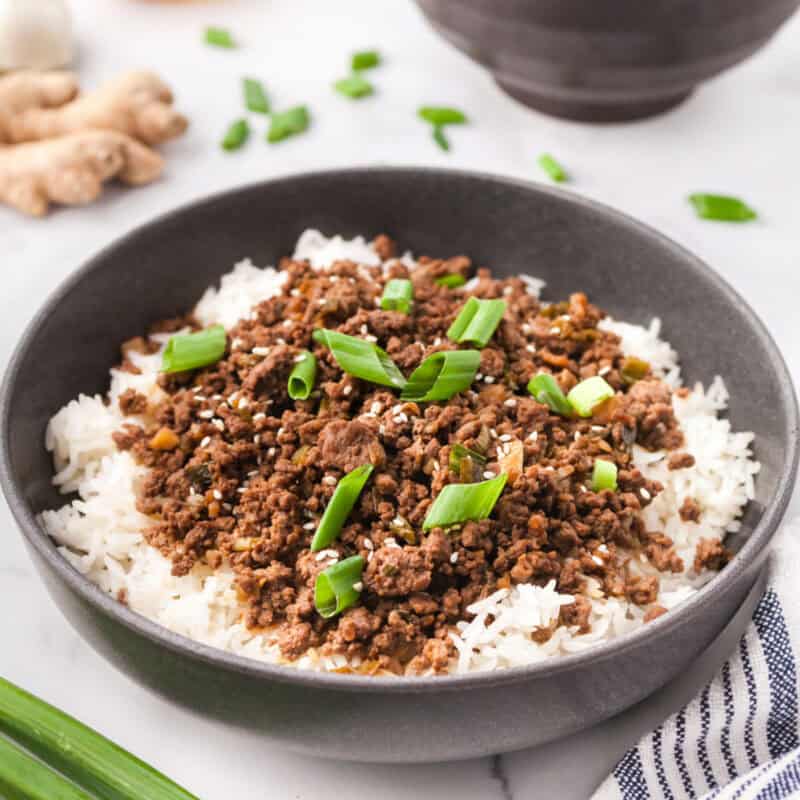 Korean ground beef in a bowl over rice and topped with green onions.