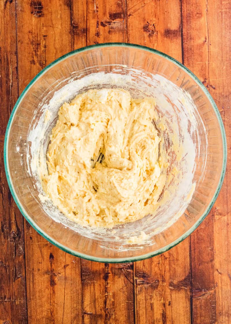Apple Cobbler batter in a glass bowl on a table.
