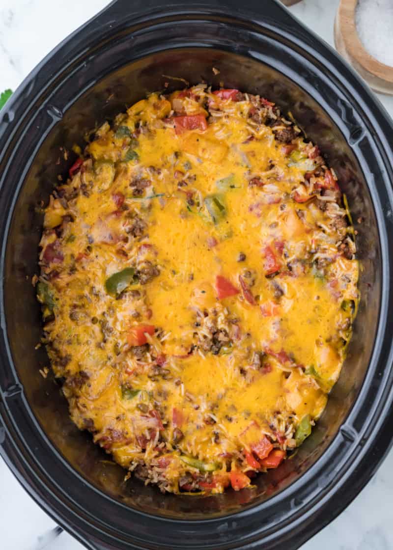 Overhead view of cooked Slow Cooker Stuffed Pepper Casserole in a crockpot dish with melted cheese on top.