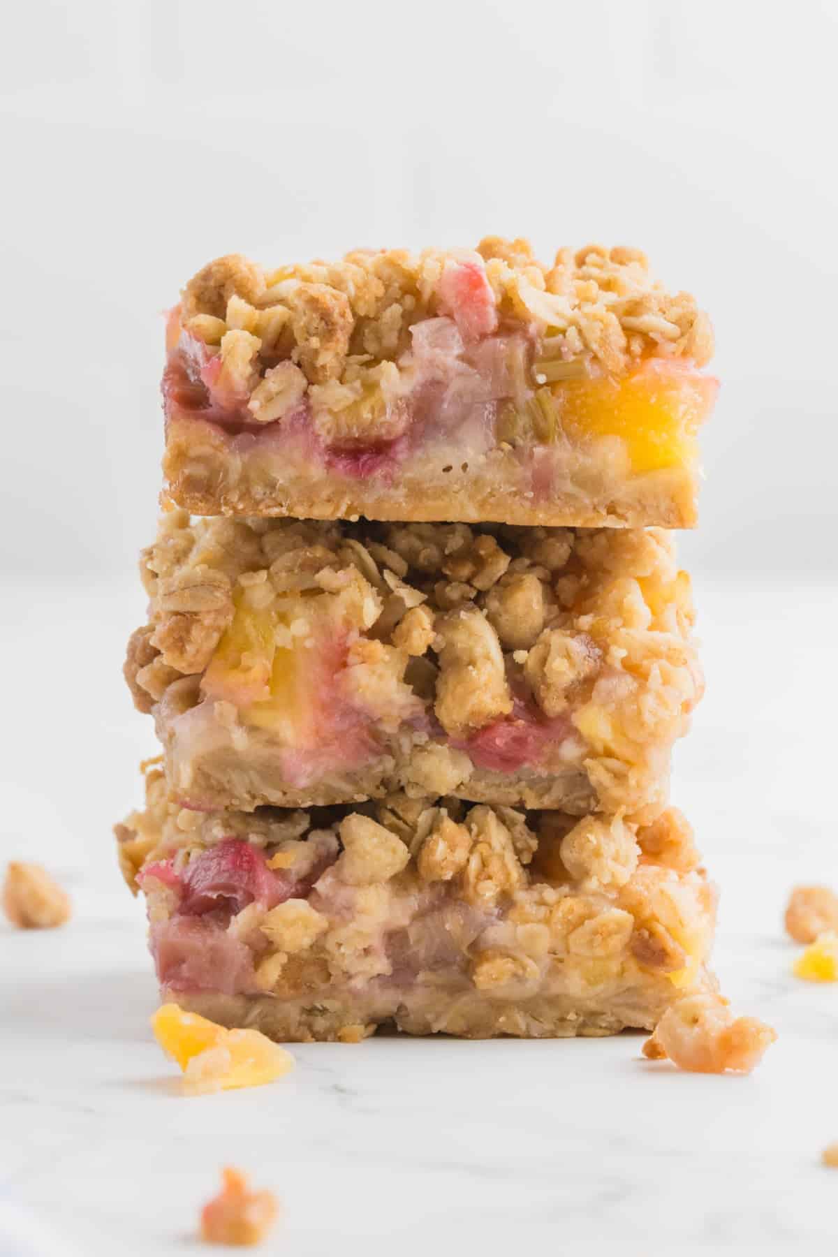 A stack of three squares of pineapple rhubarb bars.