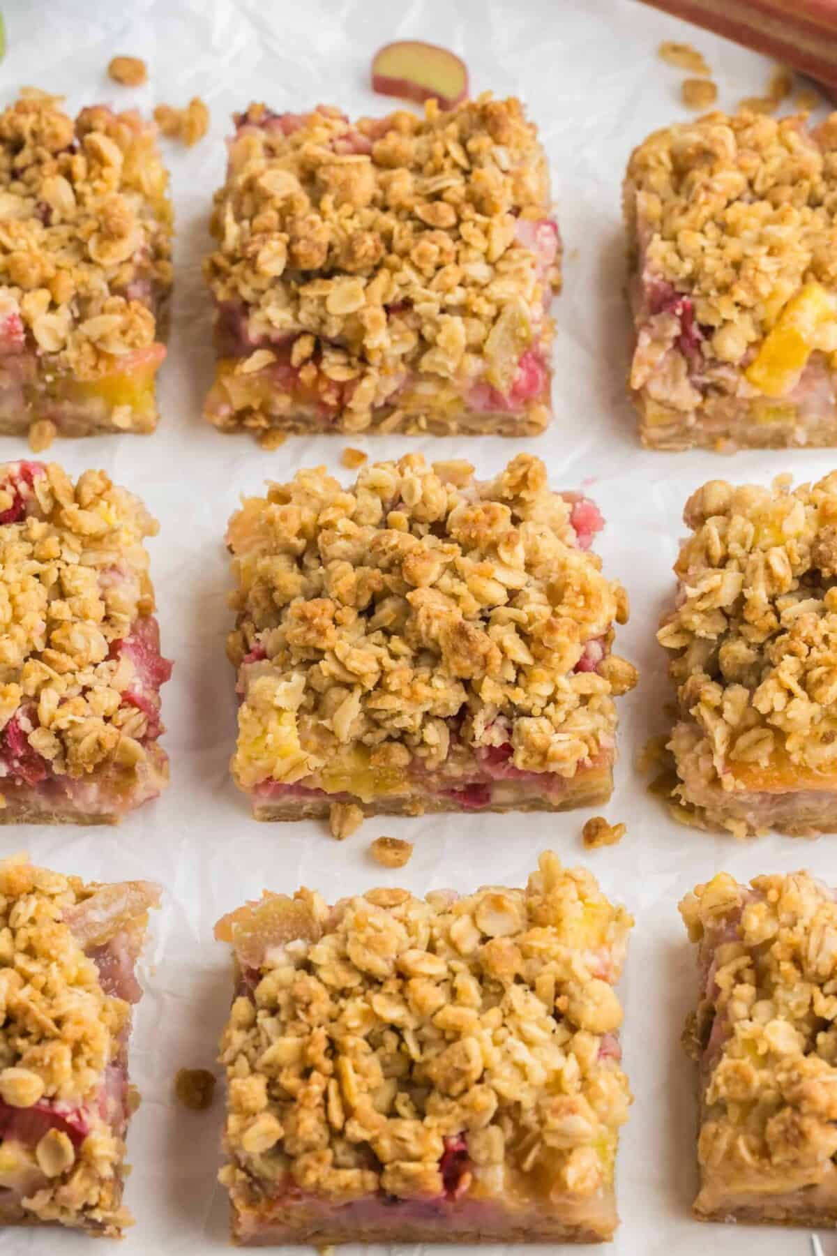 Slices of pineapple rhubarb dream bars on parchment paper.