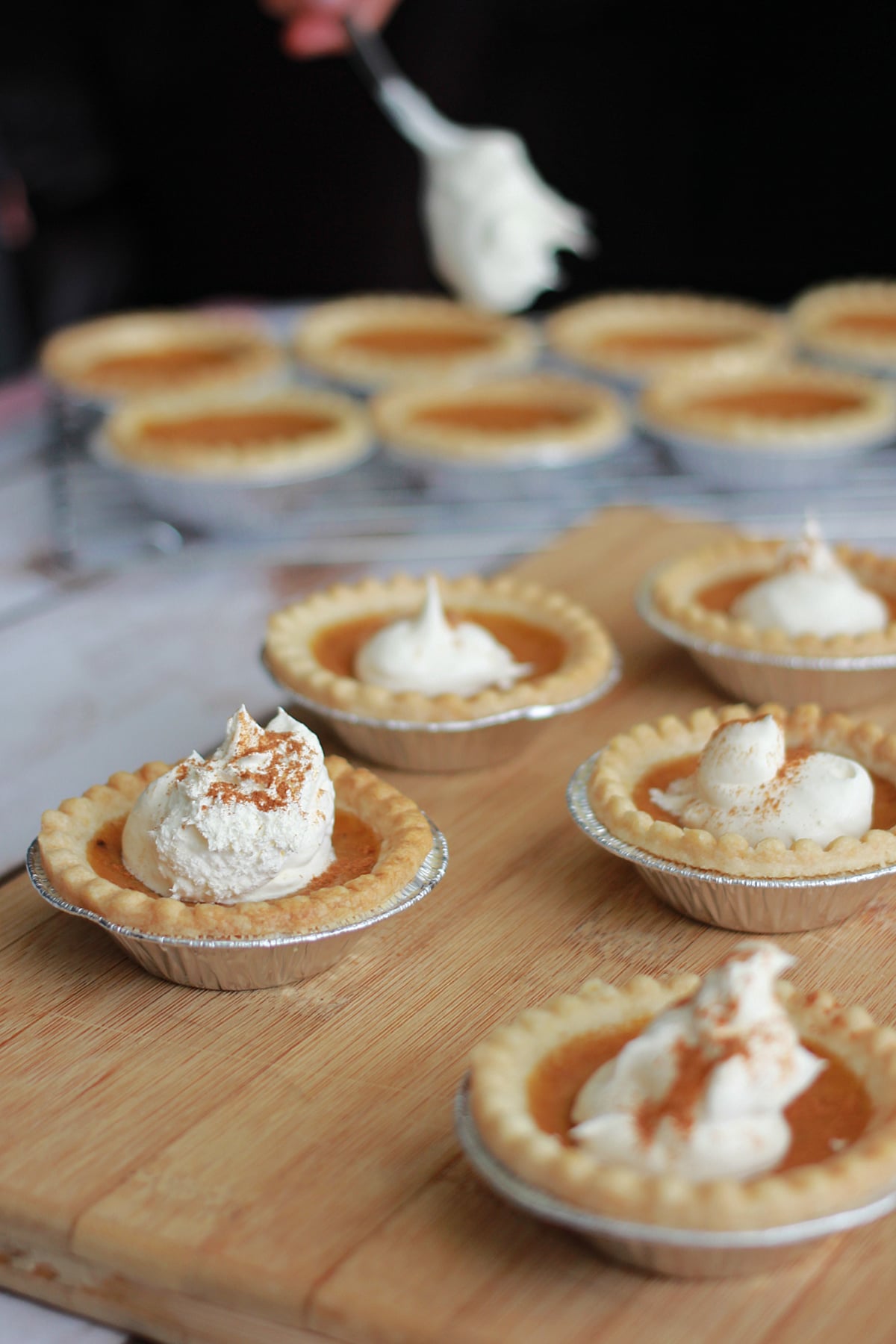 Individual Mini Pumpkin Pies with whipped cream on top.