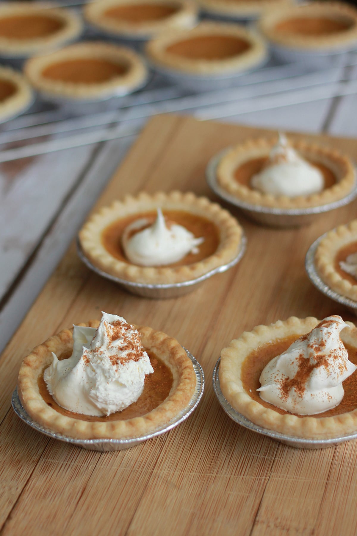 Individual Mini Pumpkin Pies with whipped cream on top.