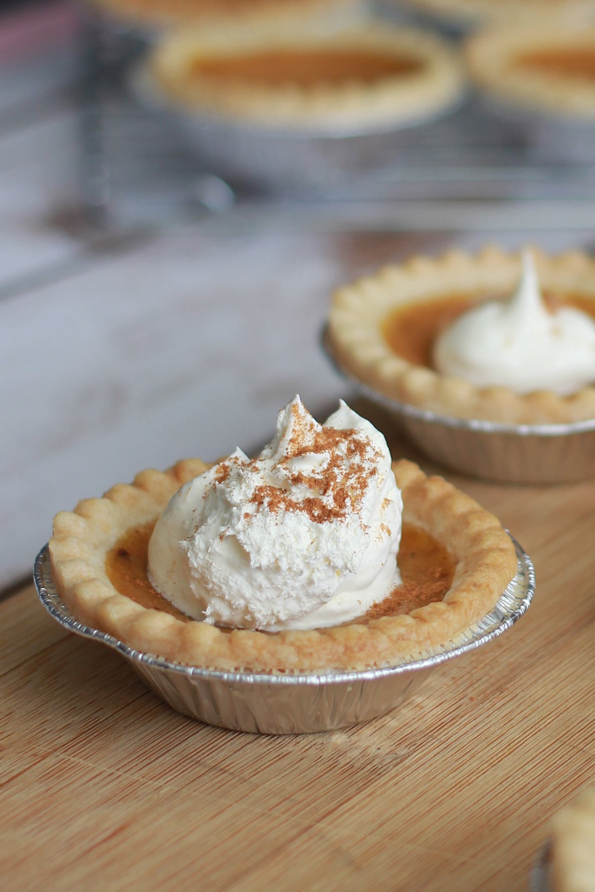 Individual Mini Pumpkin Pies with whipped cream on top.