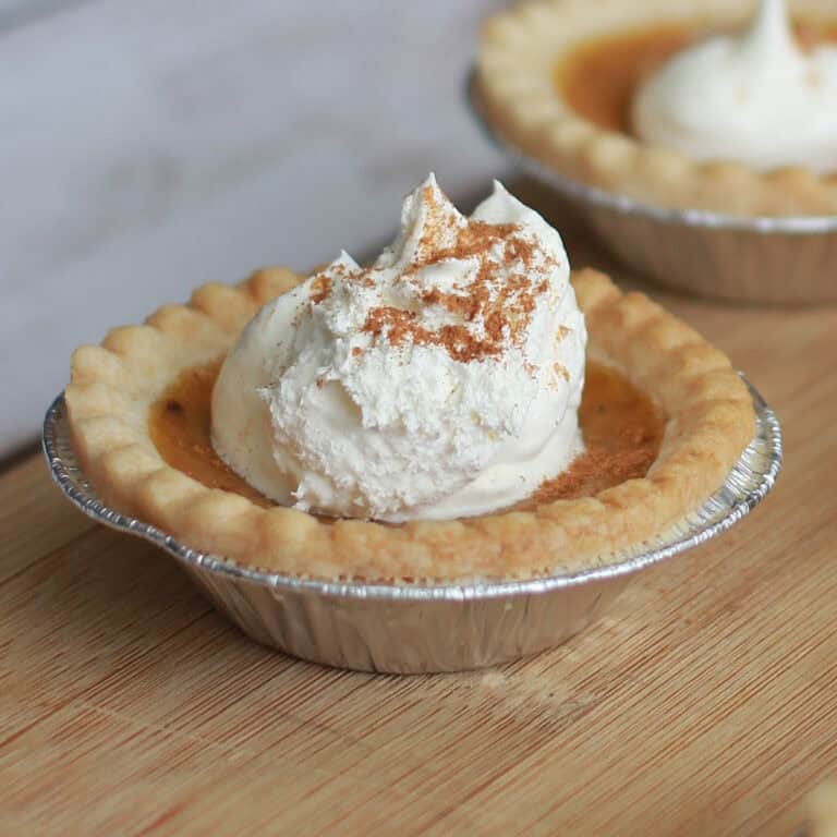 Individual Mini Pumpkin Pies with whipped cream on top.